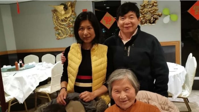 Kai Huang, un homme originaire d'Ottawa, sa  femme et sa mère posent à la table d'un restaurant.