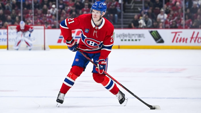 Le défenseur des Canadiens de Montréal Kaiden Guhle tire la rondelle  .