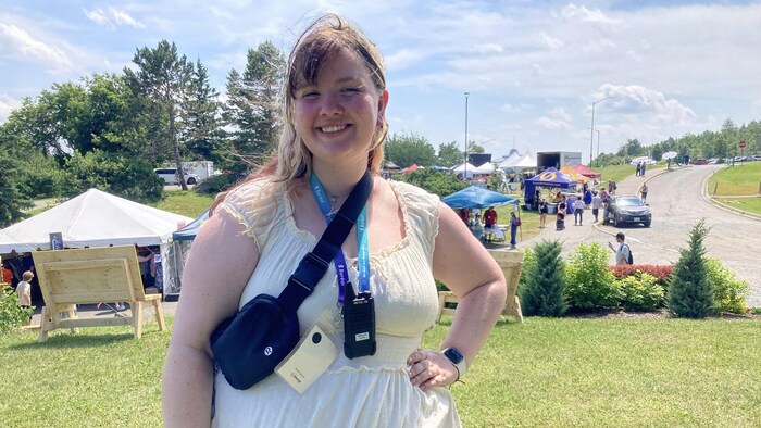 Kailin Kohls pose pour une photo devant des kiosques du Festival Boréal.
