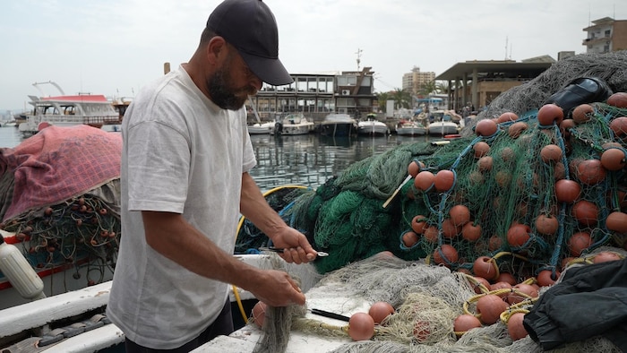 Kamal Istanbouli repairing his fishing nets.