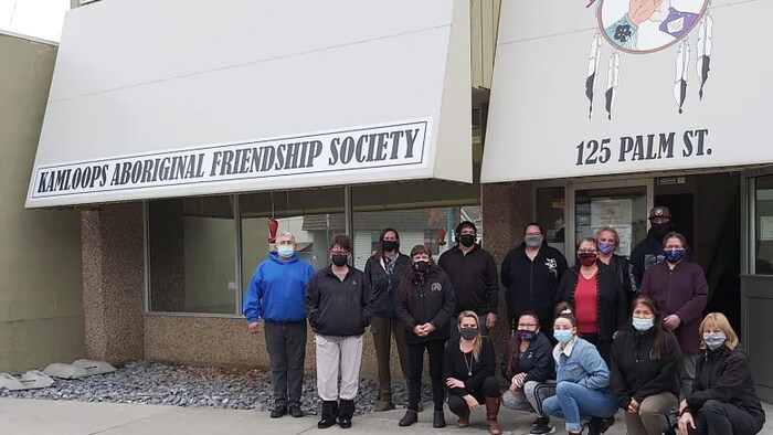 Un groupe de personnes devant le bâtiment de la société.