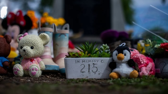 Shoes and stuffed animals on the grounds of the former Kamloops Indian Residential School on June 4, at a memorial to honour the 215 children whose remains were discovered buried there, according to a preliminary report.