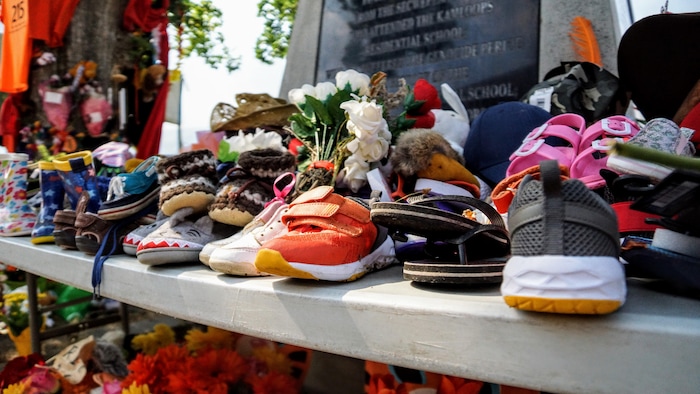 Des chaussures d'enfants disposées près de l'ancien pensionnat pour Autochtones de Kamloops au printemps 2021.