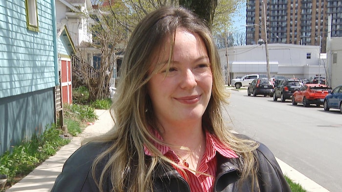 Une femme sur le trottoir, par une journée ensoleillée de printemps.