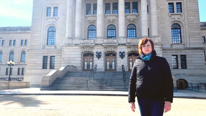 Karen Nurkowski pose à l'extérieur devant l'assemblée législative de la Saskatchewan, à Regina.