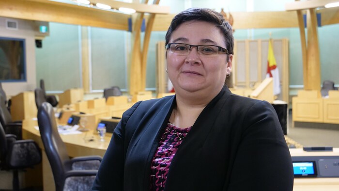 Une femme se tient debout à l'Assemblée législative du Nunavut, à Iqaluit.