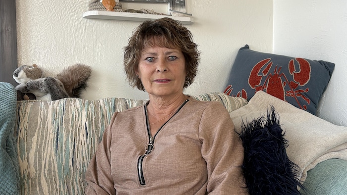 Karen Sloan assise dans son sofa dans son salon