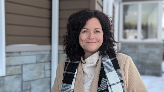 Karie Bernèche sourit près d'une bâtisse.