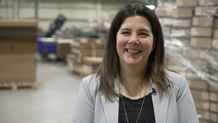 Une femme tout sourire dans une usine.