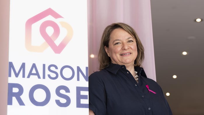 Karine-Iseult Ippersiel pose à côté de l'affiche de la nouvelle Maison Rose.