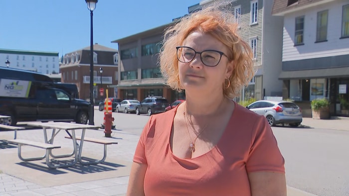 Karine Laflamme à l'extérieur devant une rue et des commerces.