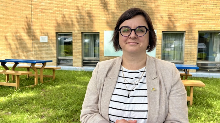 Karine Malenfant sourit pour la photo devant le collège.