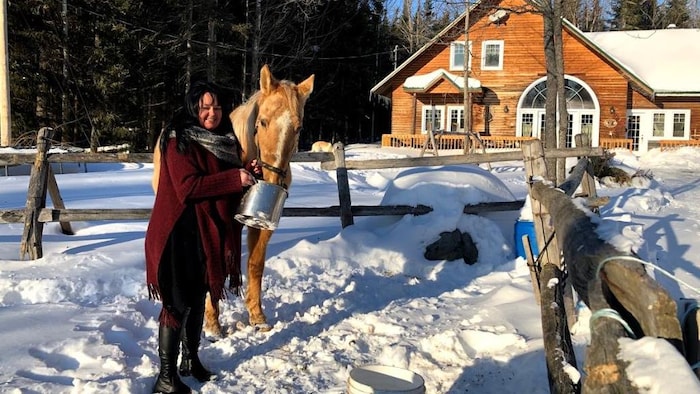 Karine Veilleux nourrit son cheval.