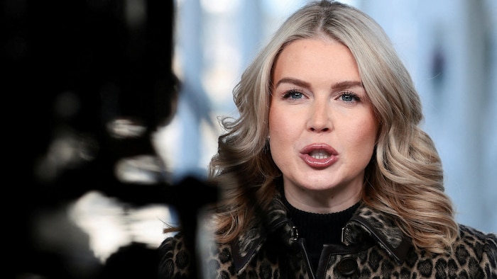     Karoline Leavitt, her mouth half open, looks ahead. 