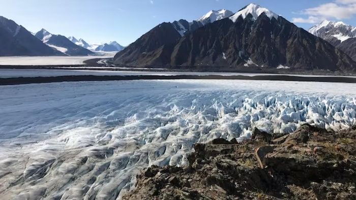 De hautes montagnes entourant un glacier.