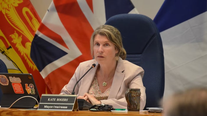 Kate Rogers siège dans la salle de réunion du conseil municipal.