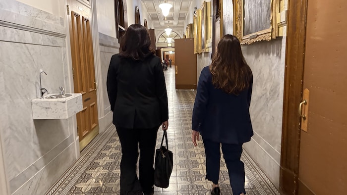 Deux femmes marchant dans un couloir.