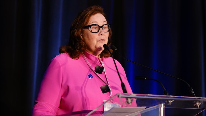 Kathleen Legault se tient debout derrière un lutrin.
