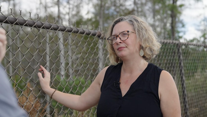 Une avocate devant les grilles d'une prison.