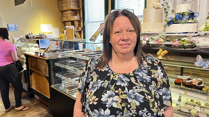 La responsable des ressources humaines à la chocolaterie Aux Bienfaits, Katy Blanchette, devant un présentoir de chocolats.