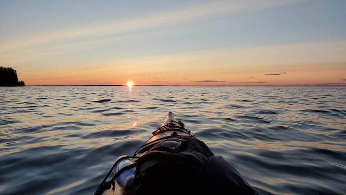 Le coucher de soleil vu d'un kayak sur le fleuve Saint-Laurent
