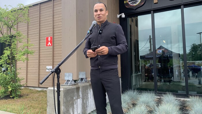 Francis Verreault-Paul parle au micro devant l'entrée du poste de police de Kebaowek.