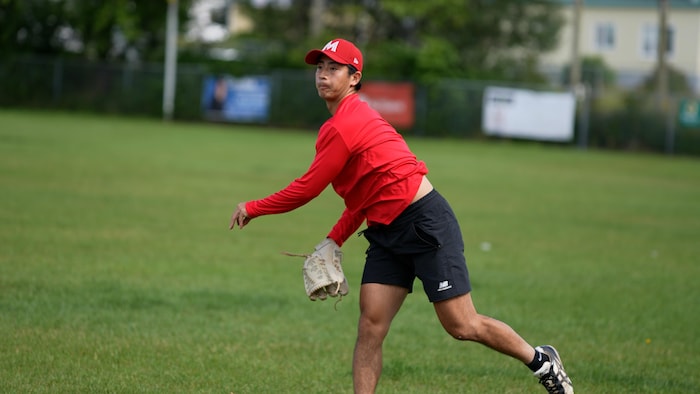 Un joueur de baseball en pleine action sur un terrain en été.