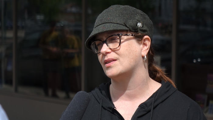 Une femme avec un chapeau dehors.