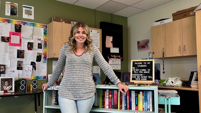 Kelsey James est appuyée contre son bureau.