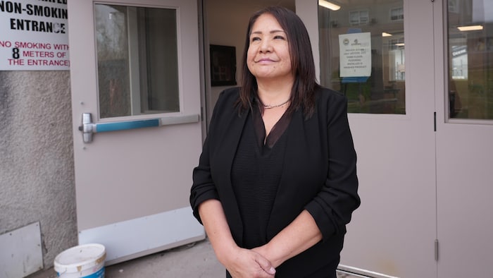 Une femme près d'une porte extérieure d'un bâtiment.