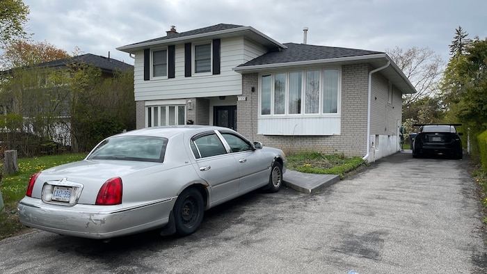 Une voiture garée devant une maison.