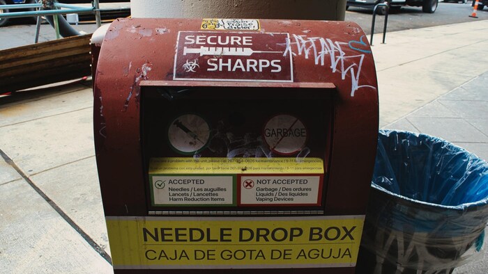Une poubelle permettant de jeter des seringues usagées devant une station de métro du quartier Kensington. 