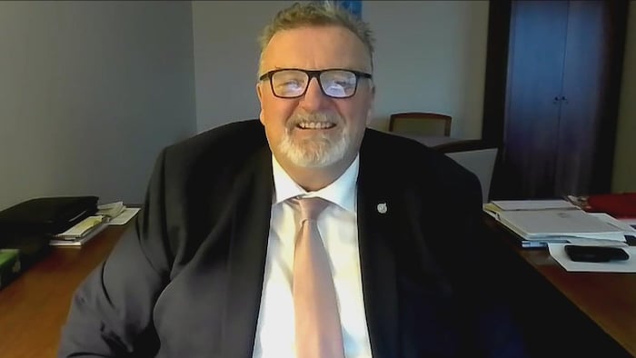 Kent MacDonald s'entretient avec le journaliste par visioconférence depuis un bureau.