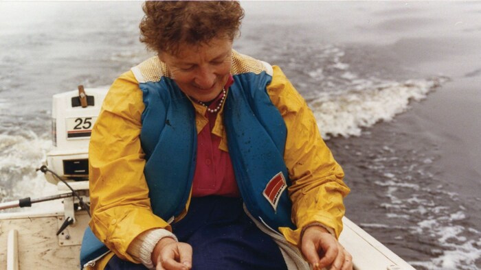 Photographie d'archives de Mme Roy assise dans un canot à moteur.