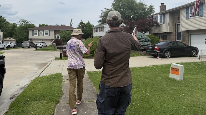 Derek Pardue et Christopher Pino font du porte-à-porte dans un quartier résidentiel du Kentucky, le 18 mai 2026.