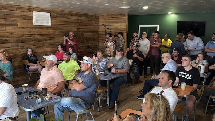 Des personnes écoutent le représentant prononcer un discours dans un café du petit village de Greenup, au Kentucky, le 18 mai 2026.