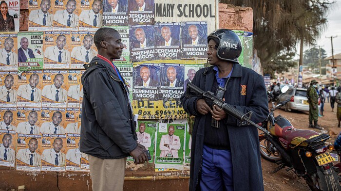 Un homme discute avec un policier kényan.