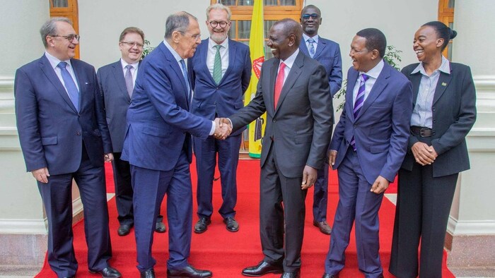 Sergueï Lavrov et William Ruto se serrent la main devant d'autres dignitaires.