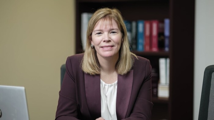 Kerry Hatfield souriante et assise à son bureau.