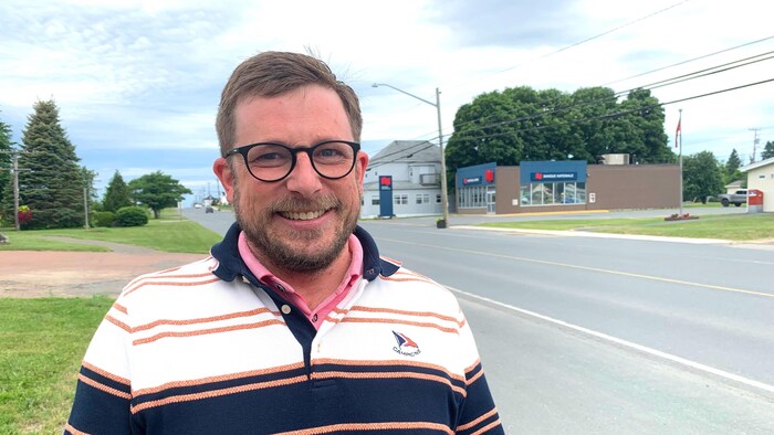 Kevin Arseneau pose pour une photo, dehors, debout sur le bord du chemin.