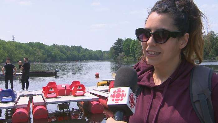 Khadidja Mohammedi parle au micro de Radio-Canada, debout sur un quai. 