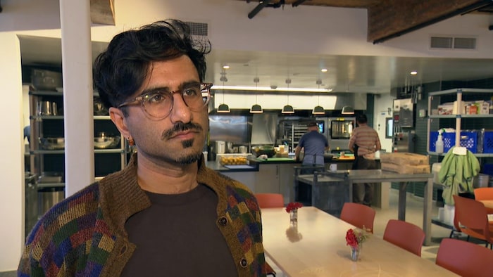 Khalid Jamal est debout dans une cafétéria.