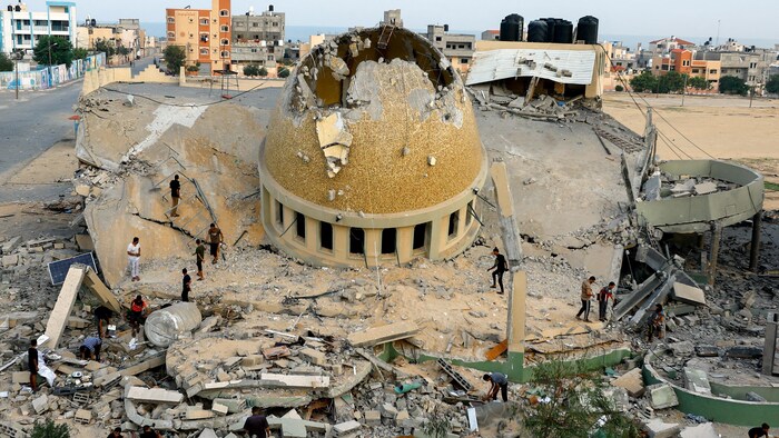 فلسطينيون يتفقدون مسجداً دمّرته غارات إسرائيلية في خان يونس جنوبيّ قطاع غزة.