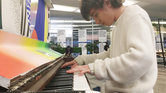 Le jeune pianiste Kian Nojoumian jouant sur un piano public au Palais des congrès de Montréal.