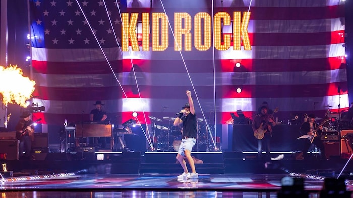 Un homme a le poing levé sur scène. 