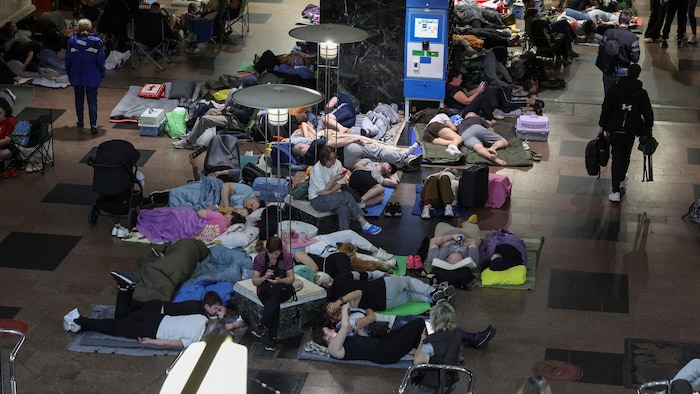 Dans une station de métro, des personnes sont installées sur des matelas de sol, se réfugiant d'attaques russes à Kiev.