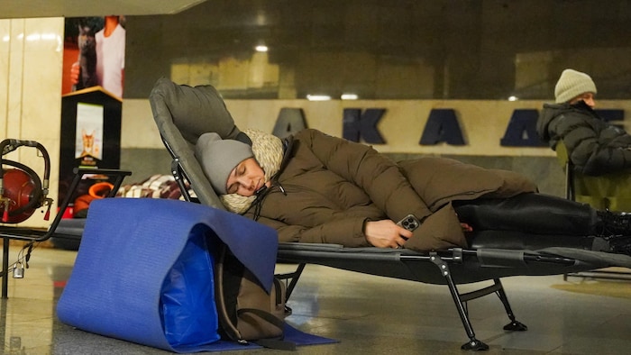 Des personnes se réfugient dans une station de métro pendant les frappes aériennes russes à Kiev le 27 décembre 2025.