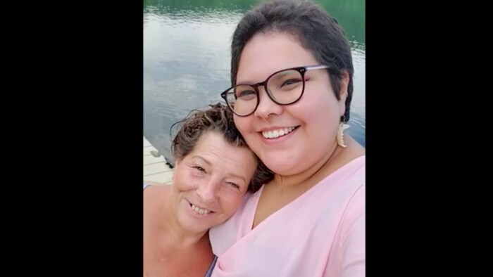 Une fille autochtone et sa mère s'enlacent.