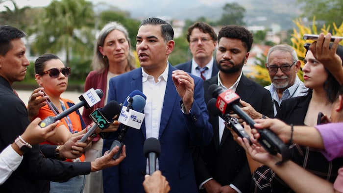 Robert Garcia et Maxwell Frost parlent, entourés de journalistes.