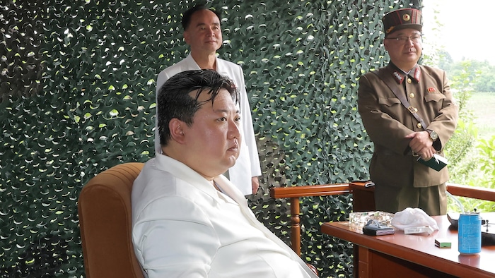 Kim Jong-un assis sous une tente militaire.